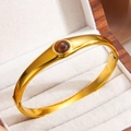 Brazalete vintage de acero de titanio dorado con piedra de ámbar redonda central - Marrón (Dorado)