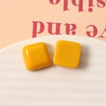 Vista macro de pendientes cuadrados de resina amarillo brillante de 15 mm con acabado de esmalte - Amarillo Tierra