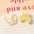 Macro detail of yellow resin butterfly charms with glitter and water ripple texture - Yellow