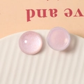 Macro-opname van 20mm doorschijnende roze glitterhars bedeltjes op een keramisch bordje - Roze