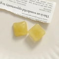 Macro view of square yellow resin charms with glossy finish for DIY jewelry crafts - Yellow