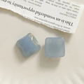 Detail of light blue square resin charms with gold glitter texture for DIY jewelry making - Blue