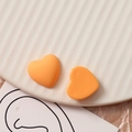 Macro-opname van matte oranje hartvormige bedeltjes voor DIY-sieraden maken - Oranje