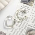 Detail of heart resin earring with black calligraphy and white pearl backing on magazine - Transparent White Heart One Piece