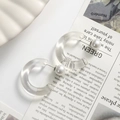 Detail of C-shaped transparent resin earrings with faux pearl on stylish background - Transparent White C-Shape One Piece