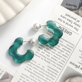 Detail of green resin flower earrings with white pearl backings on a newspaper - Green Flower One Piece