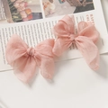 Detail von rosa Organza Schleifen Haarschmuck auf Modezeitschriften Hintergrund - Chrysanthemenrosa