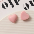 Primer plano de dijes de corazón en resina rosa brillante para joyería y accesorios DIY - Rosa