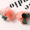 Macro detail of delicate sheer fabric silk petals and green leaves for DIY hair accessories - Pink