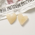 Detail view of cream yellow heart-shaped resin charms for DIY jewelry and hair accessories - Beige