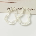 Primer plano de anillos de resina irregulares con perlas incrustadas en fondo neutro - Blanco