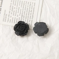 Macro view of matte black rose acrylic flower charms showing petal details and flat back - Black