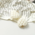 Detalle macro de colgantes de corazón acolchados blanco crema con anillos de oro retro - Blanco