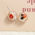 Detailed macro view of handmade glass beads with orange floral patterns and gold foil - White