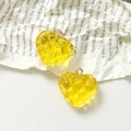 Detalle de dijes de corazón de resina acolchada amarilla con ganchos dorados sobre fondo - Amarillo