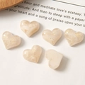 Macro detail of heart-shaped cream resin charms with gold glitter and marble texture - Beige