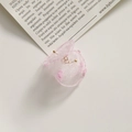 Close-up of pink organza petal earrings with gold beads on a vintage magazine background - Pink