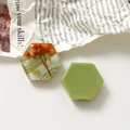 Detail van DIY hars-sieraden met marmeren textuur en florale patronen op een krant - Groen
