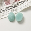 Détails macro de deux breloques en résine vert clair marbrée pour bijoux DIY - Losange / Bleu