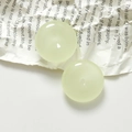 Detailed macro view of two light green resin round charms with center holes for DIY jewelry - 1 Piece / Luminous Light Green