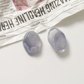 Vue détaillée macro de deux pendentifs en résine marbrée sur un fond de papier texturé - Losange / Gris Violet