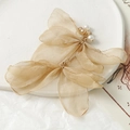 Détail d'une breloque aile de papillon en gaze champagne avec des perles blanches pures - Café Clair