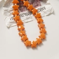 Detail van levendige oranje sterkeramische kralen op een vintage krantenachtergrond - Levendig Oranje (53#)
