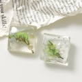 Dettaglio macro di ciondoli in resina quadrata con foglie verdi e scaglie d'argento - Verde