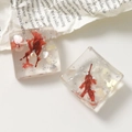 Dettaglio macro di orecchini in resina quadrati con fiori secchi rossi e argento - Rosso