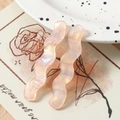 Detailansicht von wellenförmigen Anhängern aus rosa Acryl mit Perlglanz-Effekt - Orange