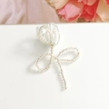 Vue macro de la broche tulipe artisanale avec des perles irisées sur socle blanc - Blanc