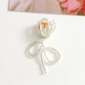 Détail macro du pendentif tulipe perlé fait main avec un nœud décoratif orange - Orange