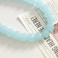 Macro shot of light blue pumpkin-shaped glass beads with clear ribbed texture - Light Blue