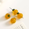 Macro detail of handmade pear-shaped glass beads for DIY jewelry and crafts with green leaves - 1 Piece / Orange