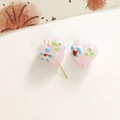 Close-up of pink heart-shaped glass beads with floral patterns for DIY jewelry making - 1 Piece / Pink