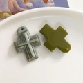 Makro-Detail von Kreuzanhängern aus Harz in Graumarmor und Olivgrün für Schmuck-DIY - Grün