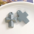 Detailansicht zweier grauer Harzkreuz-Anhänger mit gestufter Front und flacher Rückseite - Grau