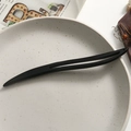 Close-up of minimalist black sandalwood hair stick with hollowed design on ceramic tray - Simple Streamlined Hollow Style (5)
