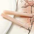 Dettaglio di eleganti fermagli per capelli in resina marmorizzata su un piatto bianco - Rosa