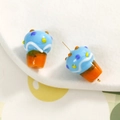 Gedetailleerde macro van handgemaakte ijs-cupcake glaskralen met kleurrijke suikerstrooisels - Blauw