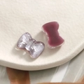 Macro shot of glittery purple and pink resin bow charms for DIY jewelry and hair accessories - Rose Purple
