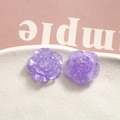 Macro shot of purple resin rose earrings with holographic sequins on a ceramic tray - Purple