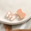 Macro view of translucent pink resin bow charms with cat-eye effect and glossy finish - Pink