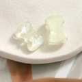 Macro shot of two light yellow translucent resin bows with a pearlescent finish - White