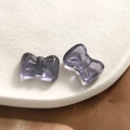 Macro shot of smoky purple translucent resin bow charms for DIY jewelry making and crafts - Black Purple