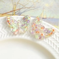 Detail of transparent resin butterflies with purple and green sequins on ceramic - Colorful