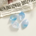 Macro-opname van bladvormige acryl hangers met blauw marmerpatroon voor DIY sieraden - Blauw