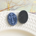 Macro detail of oval cross relief charms with brand logo for DIY jewelry making - Blue
