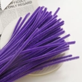 Macro shot of purple chenille stems for DIY crafts arranged on a white ceramic plate - Purple