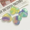 Macro shot of iridescent heart resin beads with glitter texture for DIY jewelry making - Green